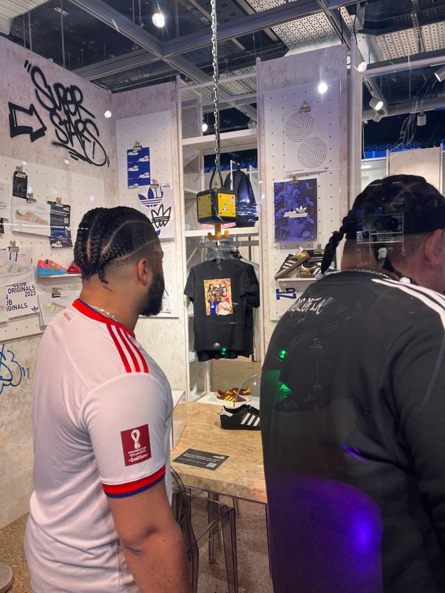 Visitors looking at the limited edition shirt on display in the Adidas store